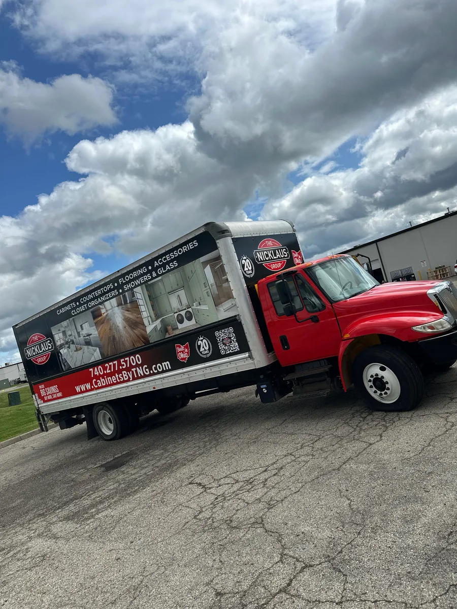 Box truck with a red cab and printed box graphics