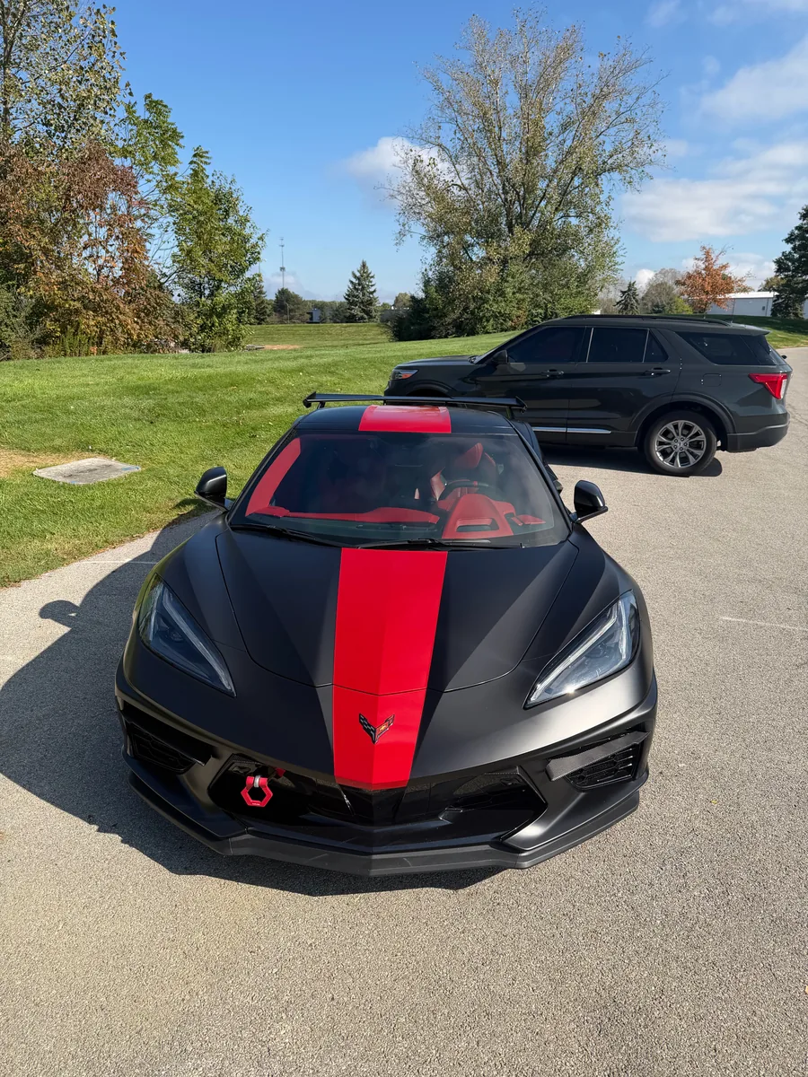 Black C8 Corvette with a red center stripe