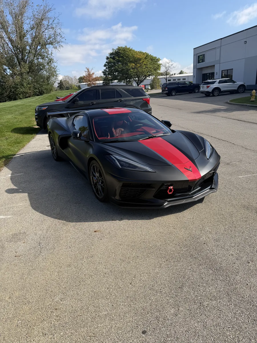 Black C8 Corvette with a red center stripe