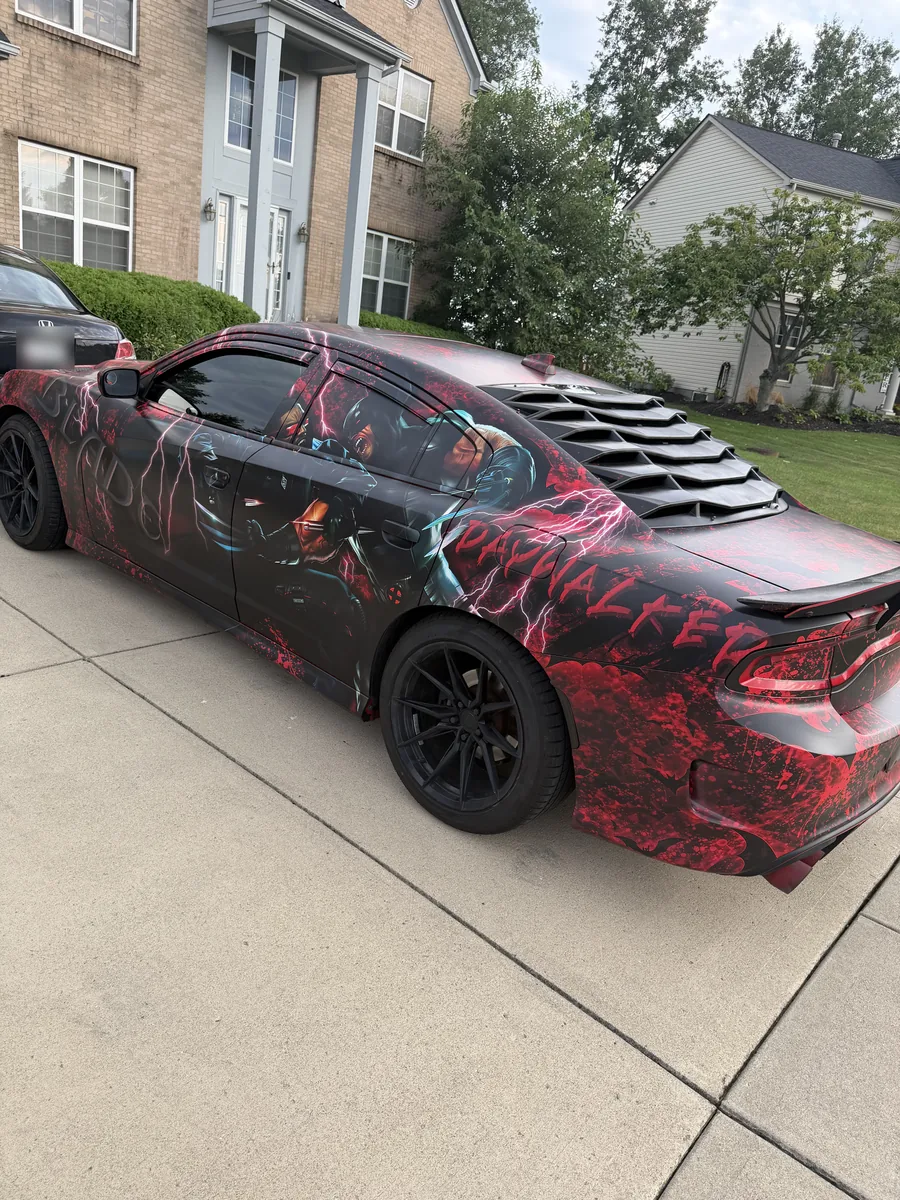 Rear view of a Dodge Charger in a red and black splatter print wrap