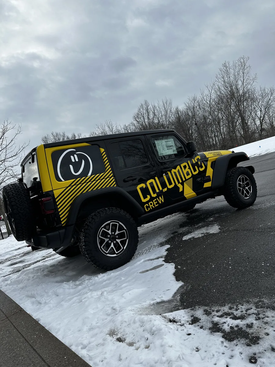 Jeep Wrangler in a yellow branded wrap in the snow