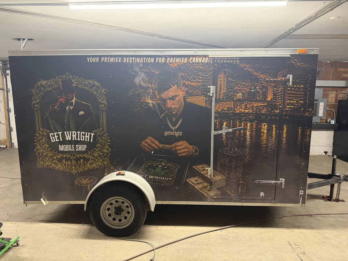 Mobile barbershop trailer wrap in a work bay